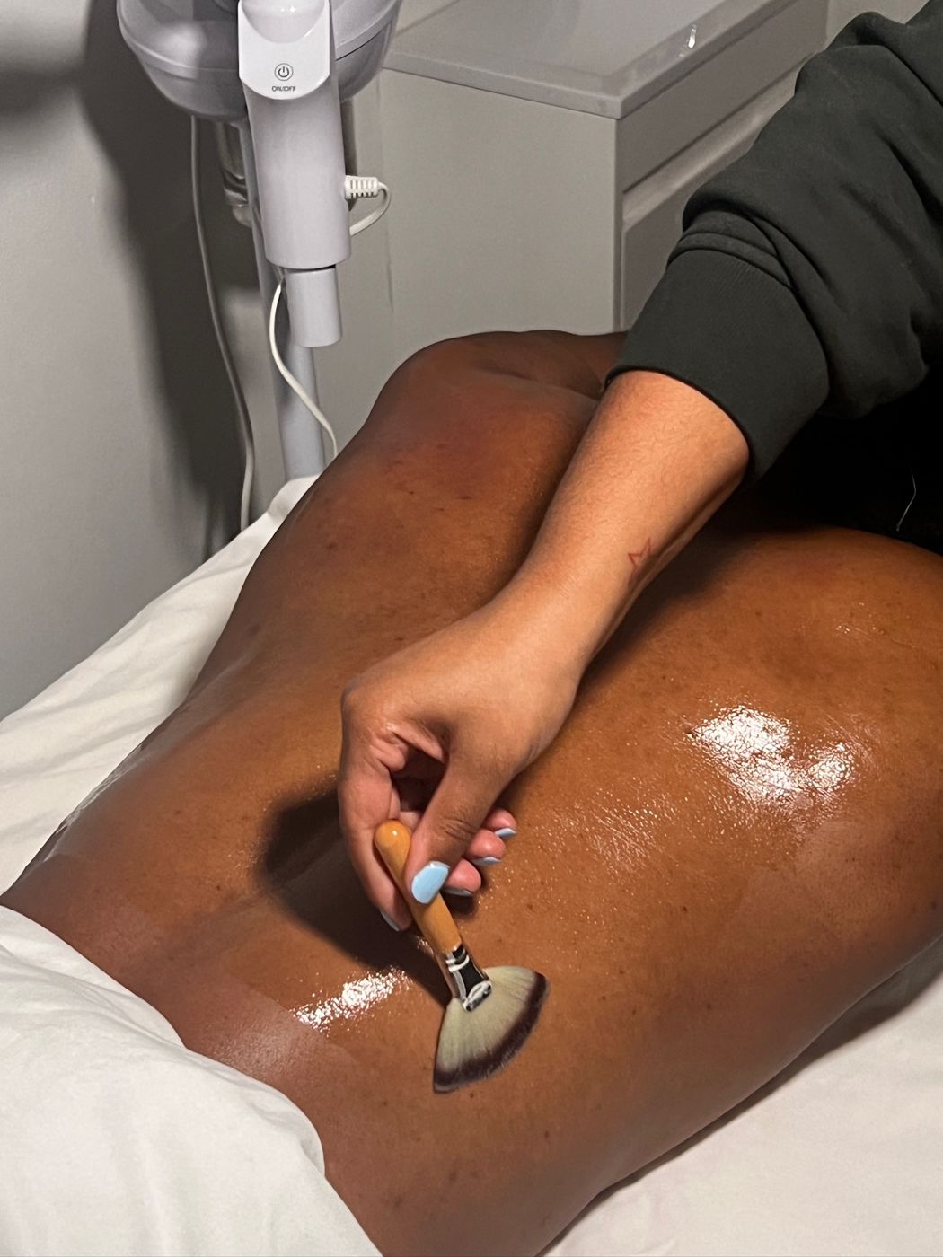 Treatment being brushed onto a client's back